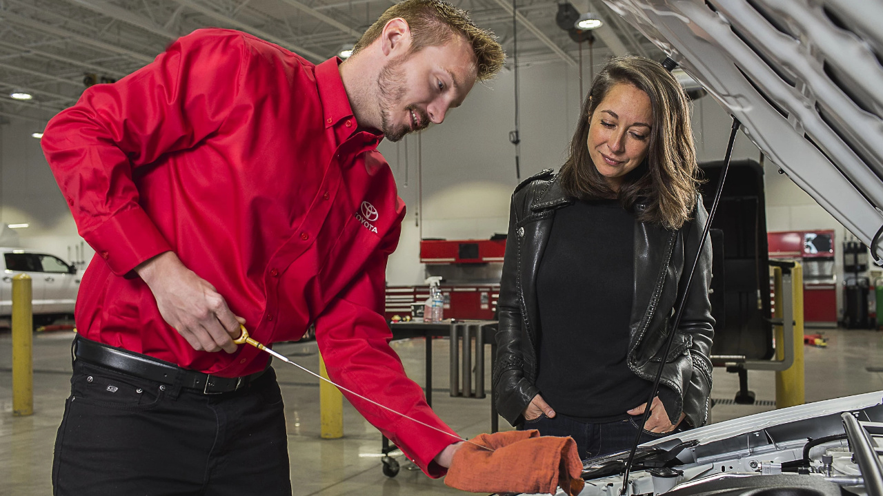 technicien Toyota en train de vérifier le niveau d'huile dans un véhicule